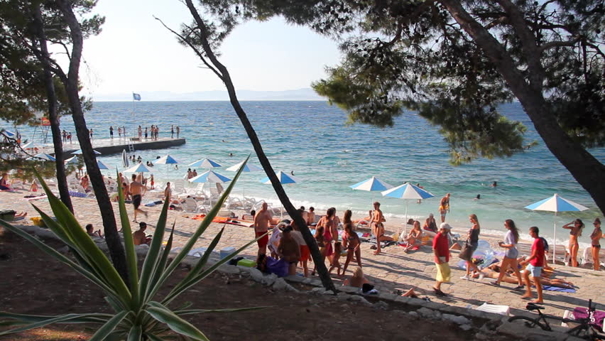 People on the beach, sunbathe and enjoy on vacation. Summertime at Adriatic Sea on the island Brac in Croatia