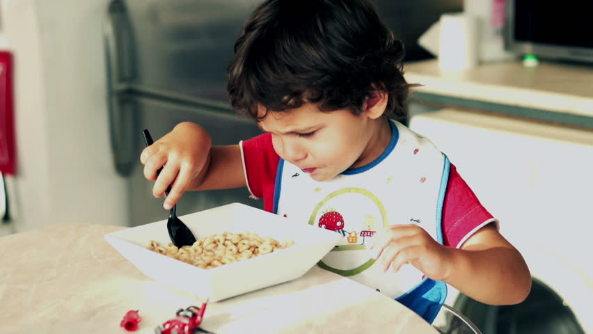 Little boy eating cornflakes with milk, slow motion shot at 120fps
