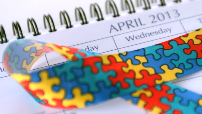 Awareness ribbon falling on calendar marking awareness day in slow motion