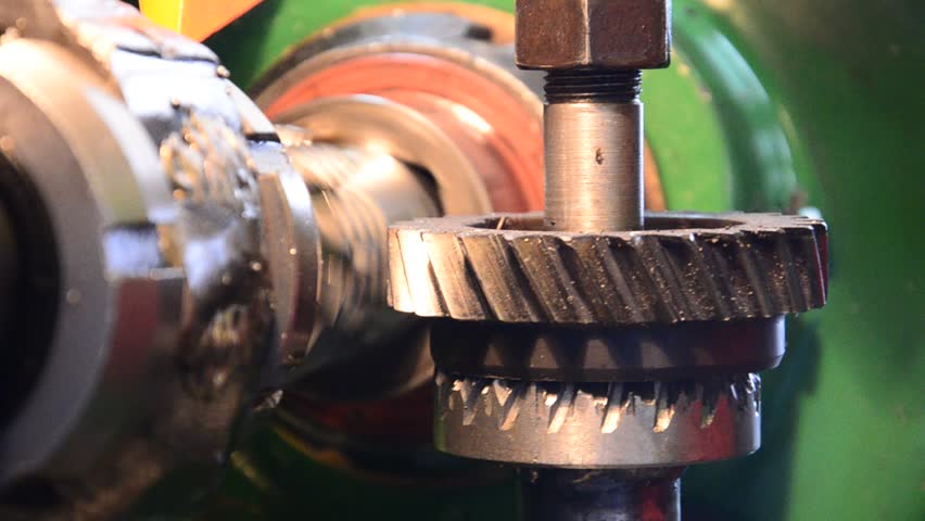 cogwheel production and service industrial machine, rotating gears closeup view