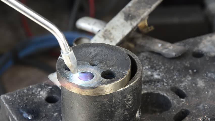 Oxygen, close-up of metal heating and welding made with gas high temperature machine. Blue flame is heating metal till red colour and it starts melting.