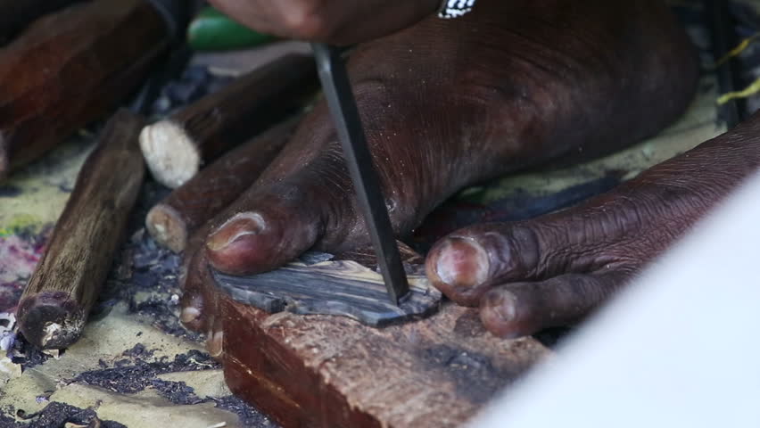 African carver creating a souvenir for tourists