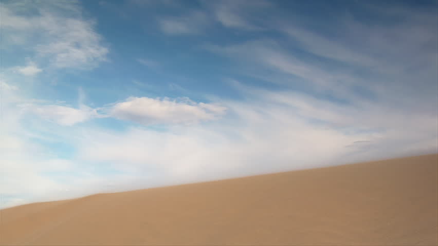 ATV rider jumps sand dune slow-motion