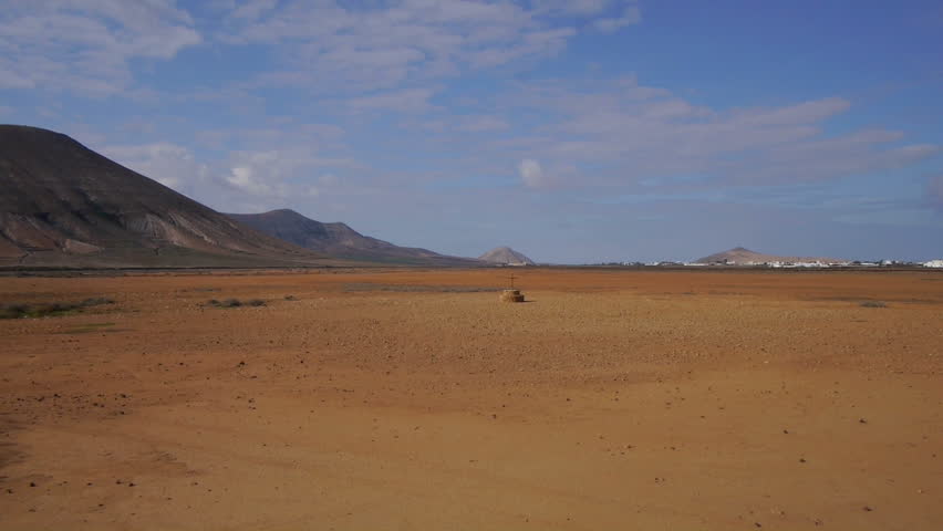 AERIAL: flying over the well in desert on Canary island, Spain. Village in the background.