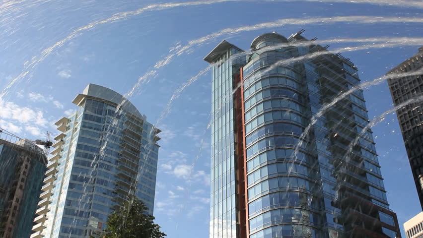 Coal Harbor Condominiums and Fountain, Vancouver. Condominiums in downtown Vancouver's upscale Coal Harbor. A fountain sprays water in the foreground. British Columbia, Canada.
