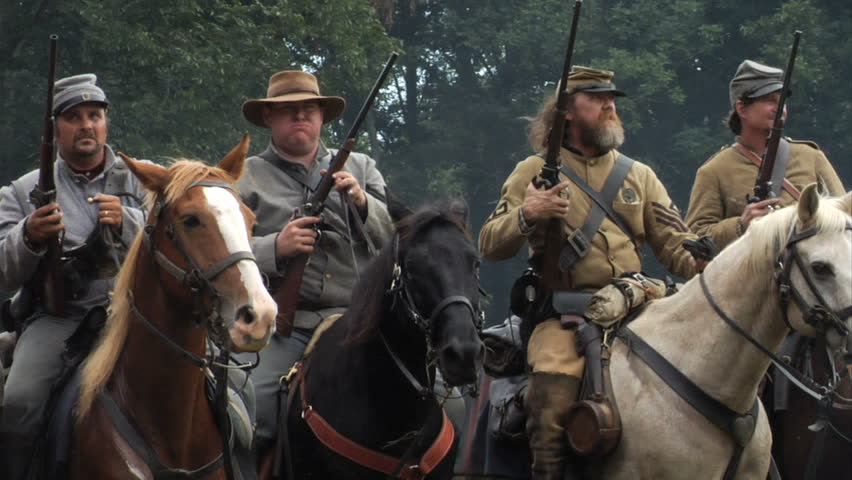 GEORGIA - OCTOBER 2008 - large-scale, epic Civil War anniversary reenactment -- in the middle of battle.  Confederate Cavalry, pistols and rifles ready, ride into battle in an organized line.