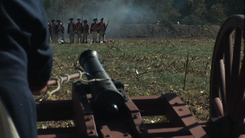 VIRGINIA - OCTOBER 2009 - large-scale, epic American Revolutionary War anniversary reenactment -- in the middle of battle.  Continental Army (or British) cannon crew loads and fires iron cannon