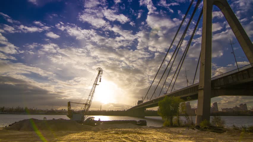 Crane unloads sand in the water. Time-lapse