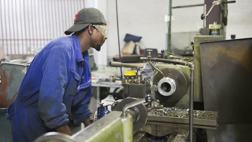 An industrial service repairmen labouring in workshop, selective focus, working on industry machine 