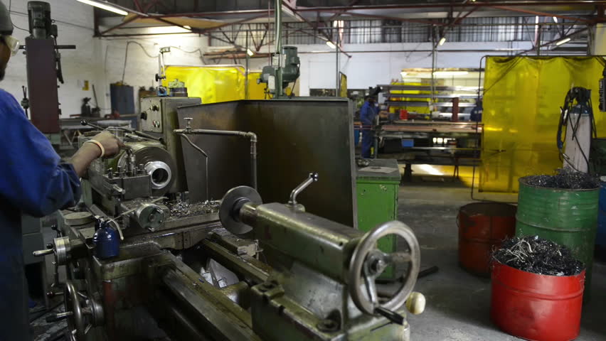 An industrial service repairmen labouring in workshop, selective focus, working on industry machine 