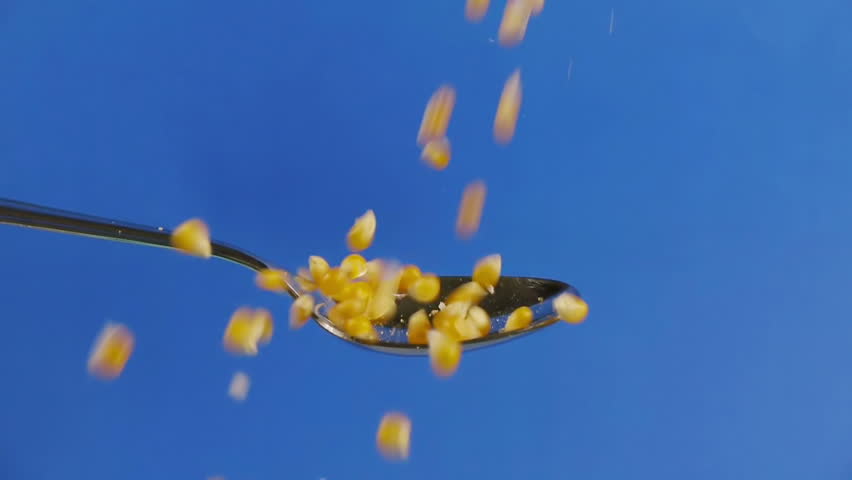 Corn Seeds Dropped On Spoon Slow Motion. Shot at 60p conformed to 24p.