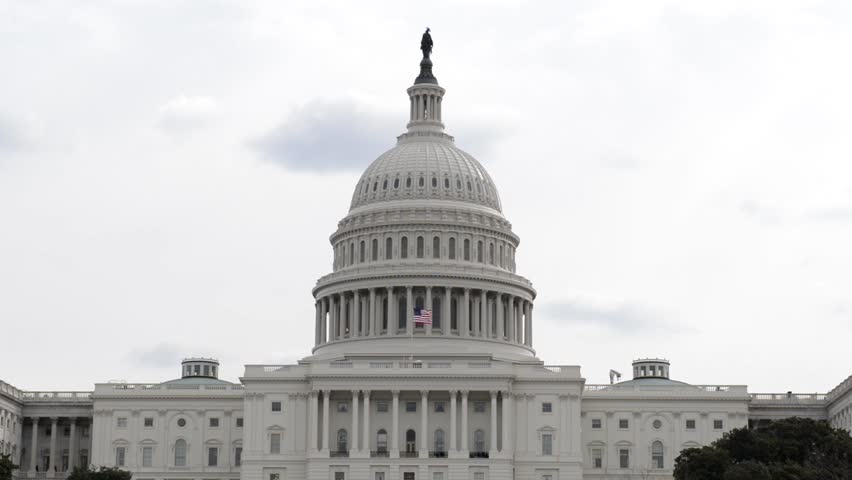 Capitol Hill in Washington DC with Flag Flying on Cloudy Day