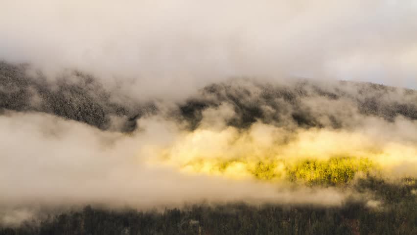 Misty Cloudy Morning with Sun Light Shining on Mountain in BC, Canada. Photo Sequence shot in RAW and Post-Production in After Effects.