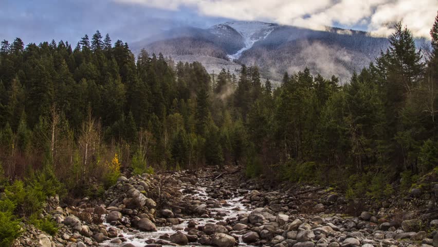 Misty Clouds on a Snowy Mountain Top and River Running. Shot in BC, Canada. Photo Sequence shot in RAW and Post-Production in After Effects.