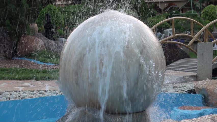 Spinning Ruby Stone: A heavy round granite stone is amazingly spinned by the nimble  power of water. Located at the Bonsai Garden, Sri Ganapathy Sachchidananda Swamiji's Ashrama. Mysore, India.
