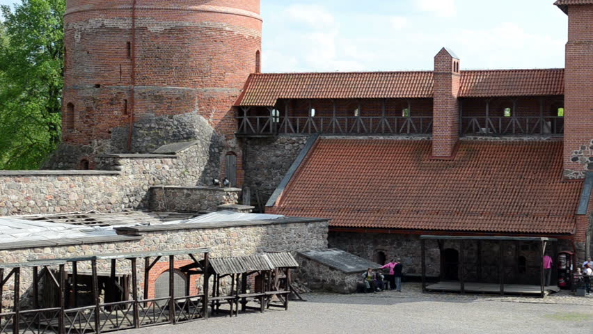Galve lake yard of ancient Trakai castle and tourist people.
