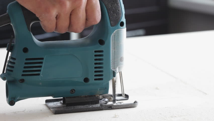 worker saws an electrofret saw plywood