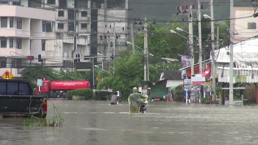 People walking on flooded street in Phuket Thailand