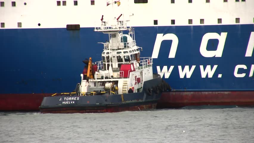 ALICANTE, SPAIN â APRIL 04: The tug "J. TORRES" is working with the general cargo vessel âTELEGHMAâ for entering in the port of Alicante; Spain; on april 04, 2013 in Alicante.