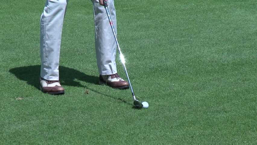 Golfer striking a ball during a match
