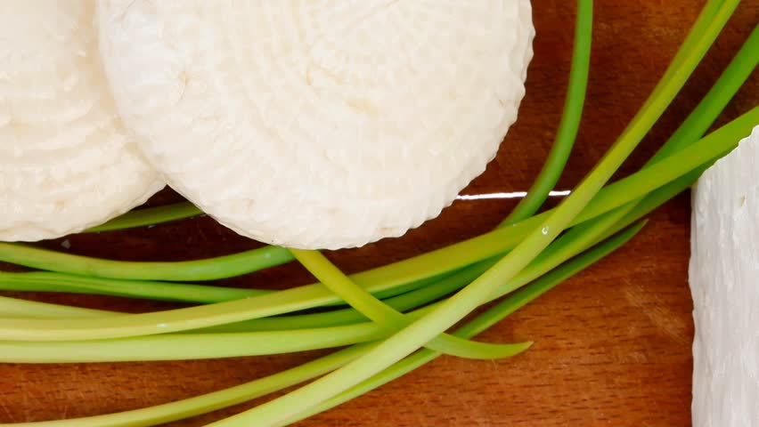 diet food : greek feta white cheese served on small wooden plate isolated over white background