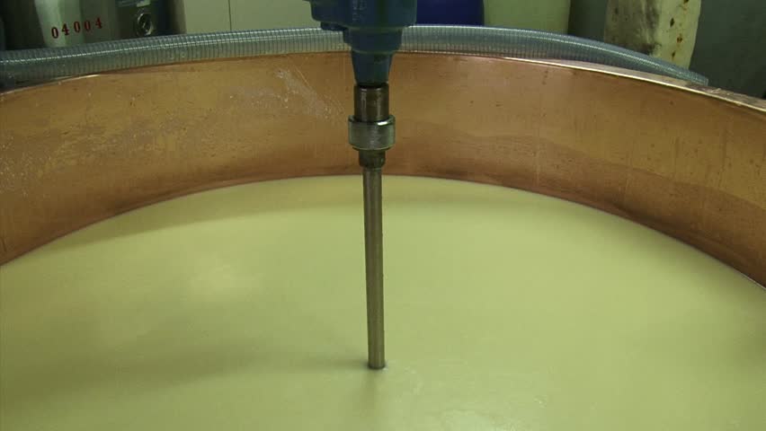 Making cheese: Stirring and heating curd mass in copper cauldron to 52?C to release more whey