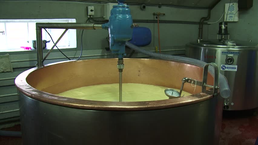 Making cheese: curd mass in copper cauldron + pan cheese molds