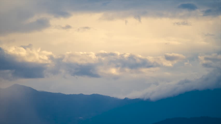 Time lapse of  clouds over a big mountain.Light fads to dark