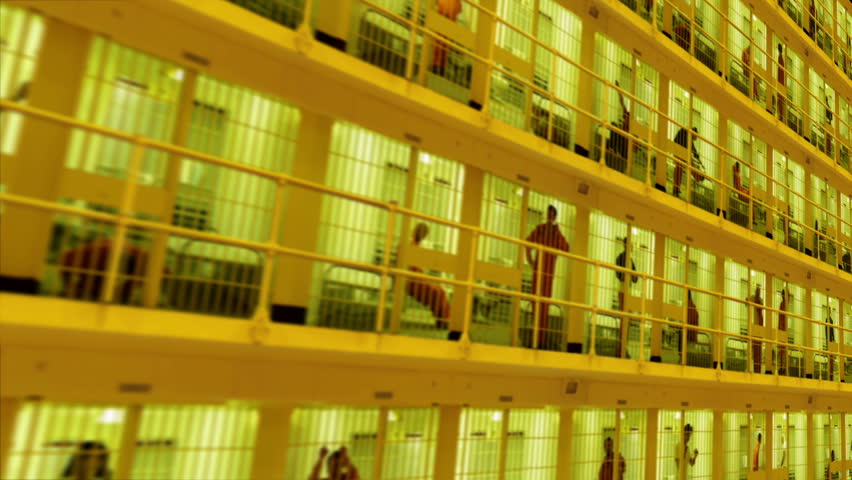 Camera moves past rows of prisoners serving time in a large cell block. Composite clip created by putting together multiple videos with still photo elements and animating in After Effects.