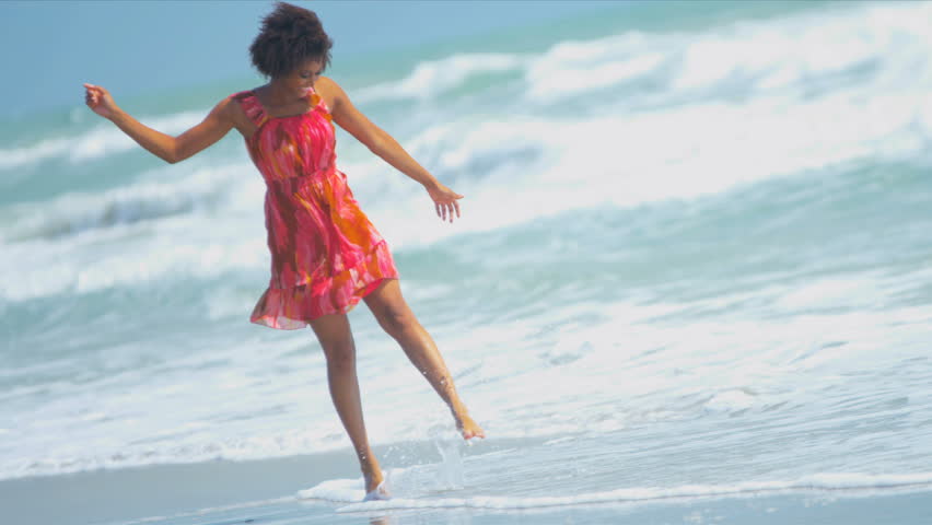 Pretty girl in sundress reveling being alone in ocean on beach vacation shot on RED EPIC