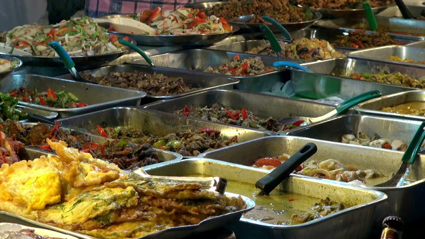 Thai street food stall / vendor packaging food behind a street food stall in Thailand
