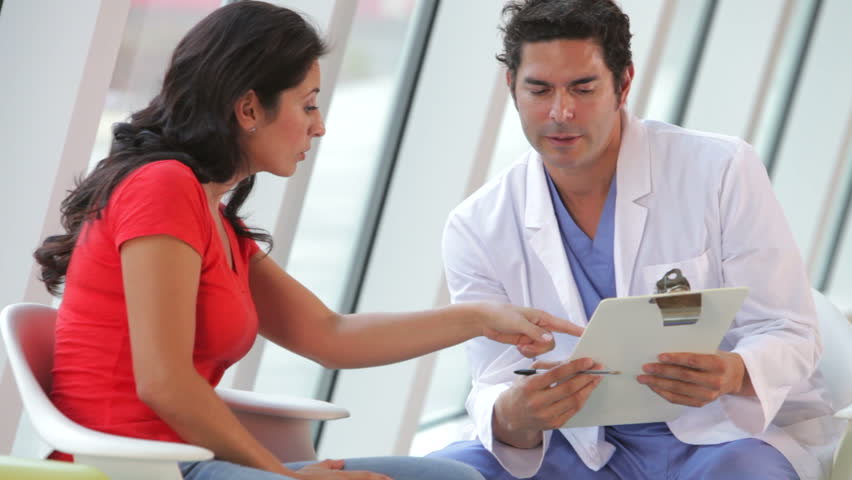 Doctor discusses female patients notes on clipboard. Shot on Canon 5d Mk2 with a frame rate of 30fps