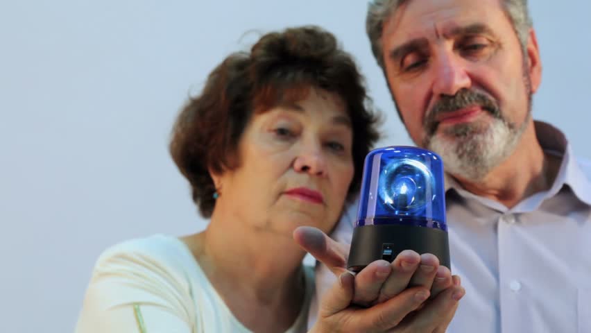 Pair of old people hold flasher on hands, focus on device
