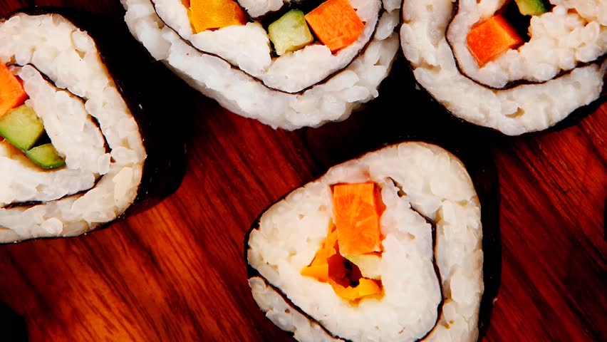 Japanese traditional Cuisine - Roll with Cucumber Cream Cheese with raw Tuna(maguro) and Salmon(sake) inside. on wooden plate with wasabi and ginger isolated over white background