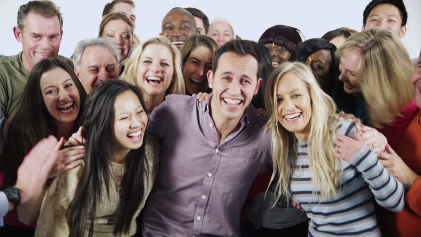 Portrait of a large and diverse multi ethnic group of people who are standing together, in brightly colored casual clothing and having fun. They are isolated on white in a studio shot.