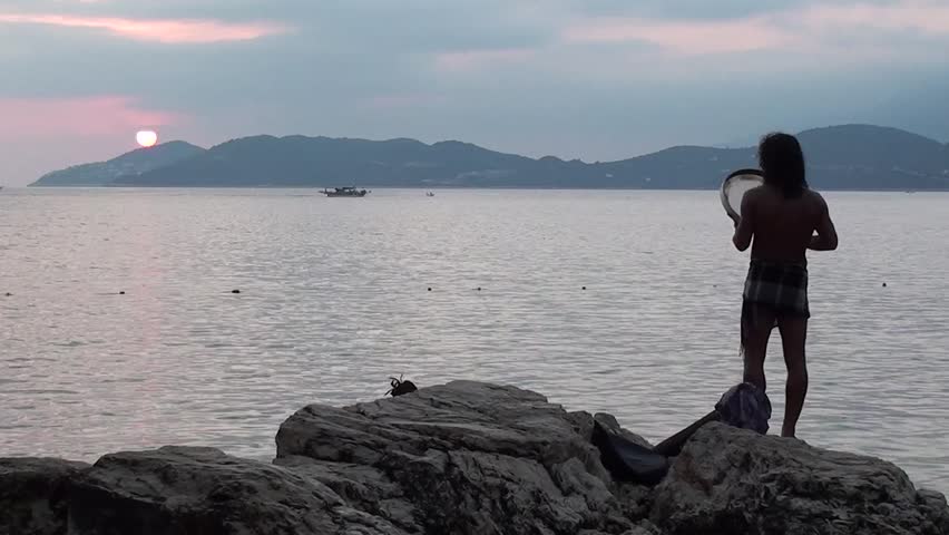 KAS, TURKEY â 12 August 2012: Aboriginal music concert at the Buyuk Cakil Beach - A man is singing OM and playing tambourine, audio