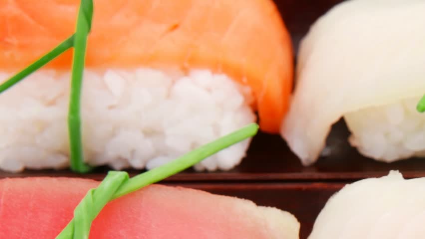 Japanese traditional cuisine - Different Types of Nigiri Sushi : Tuna (maguro) Salmon (sake) and Eel (unagi) with Wasabi and Ginger on bamboo mat 1920x1080 intro motion slow hidef hd