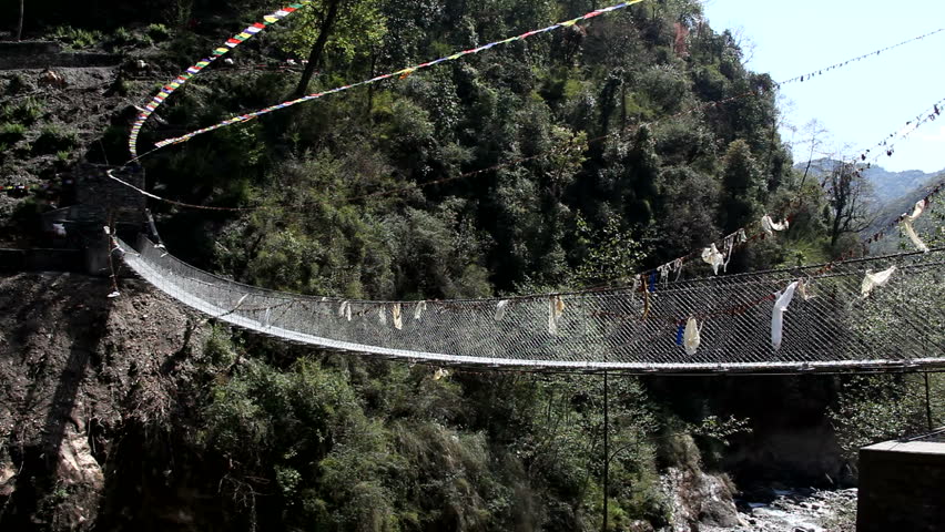 River Bridge In Rural Nepal Buddhist Prayer Flags. Gurkha built bridge in rural area of Nepal also features Buddhist prayer flags. Shot in full HD 1920x1080 30p on Canon 5D Mark II.