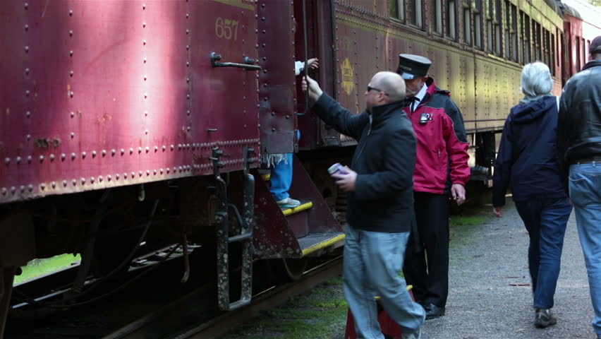 FT BRAGG CALIFORNIA APR 2013: Major tourism economic employment is Skunk Train railroad through redwood forest. Passengers exiting with help from conductor. Heritage historic antique train.