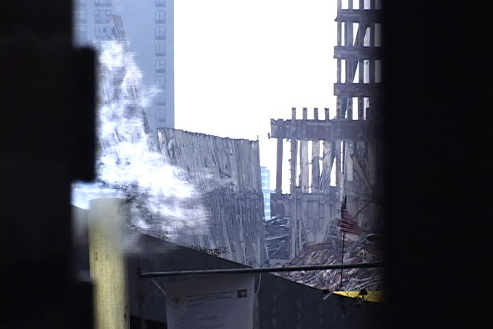 NEW YORK CITY - SEPTEMBER 28, 2001: Pit of rubble and remains of World Trade Center. Pipe emitting smoke and passing pedestrians in foreground.
