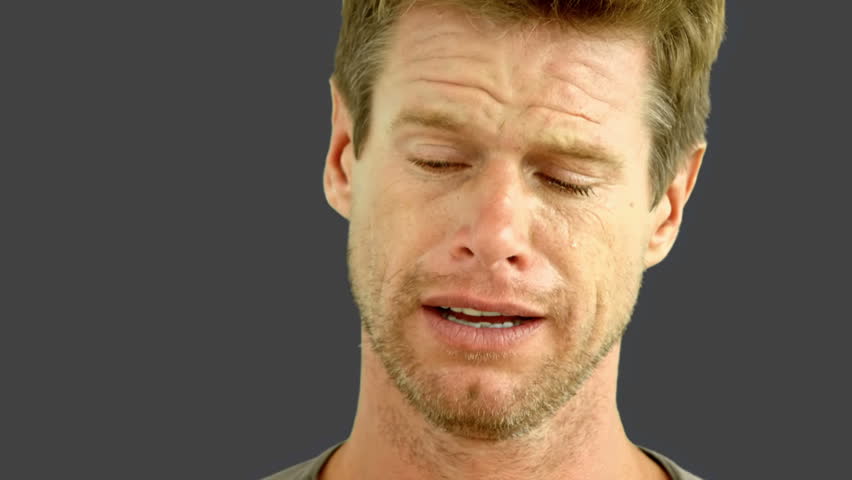 Man crying on grey screen in slow motion