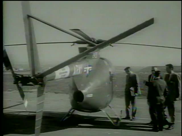 Experts look at the military helicopter on an airfield Los Angeles circa 1964-MGM PICTURES, UNIVERSAL-INTERNATIONAL NEWSREEL, USA, filmed in 1964  