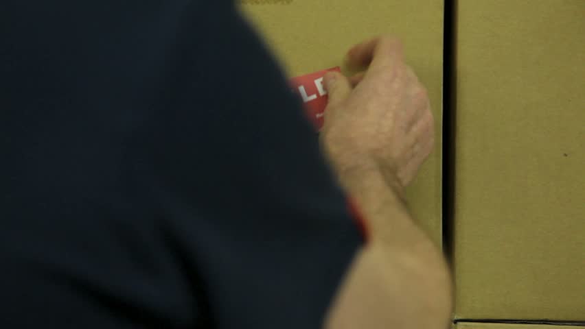 Warehouse, placing a FRAGILE sticker.