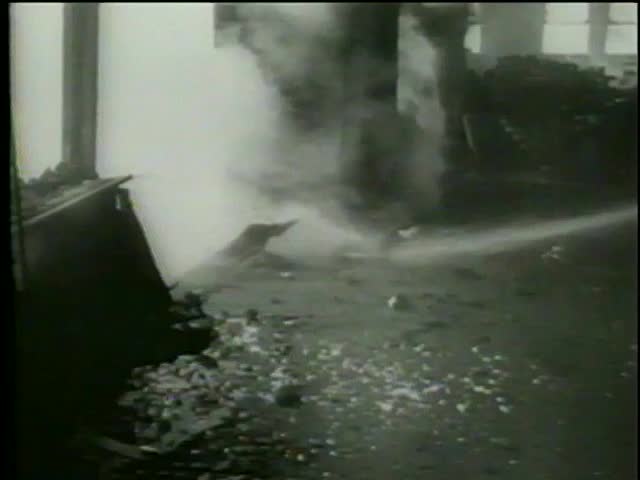 Firefighters hose down a flame at Empire State Building due to impact damage from airplane on July, 28, 1945 in New York City-MGM PICTURES, UNIVERSAL-INTERNATIONAL NEWSREEL, USA, filmed in 1964