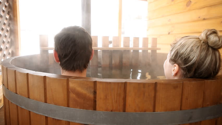 Couple sitting in hot water outdoor at winter