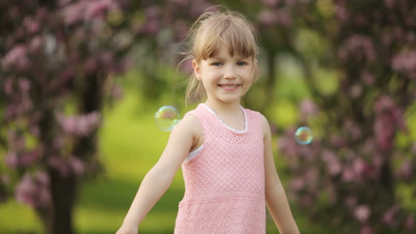 Girl spinning in park and smiling
