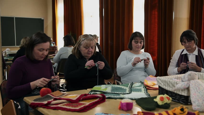 Teacher is demonstrating basics of knitting to the course participants