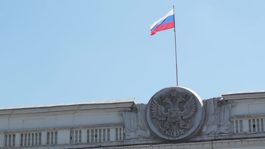State emblem and state flag of the Russian Federation in the blue sky