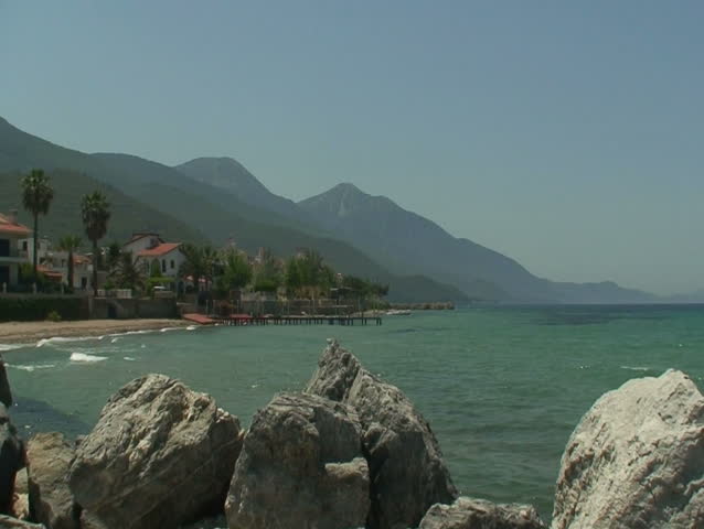 Villas on the seafront with mountains in the background