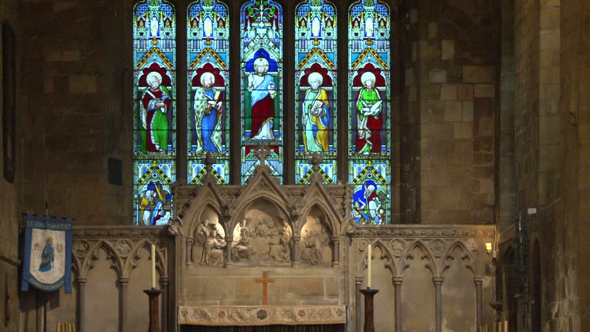 Stained glass windows behind the chancel and nave of a church.